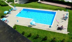 an overhead view of a swimming pool with people sitting around it at Penthouse Tgesa Tgampi T33 in Savognin