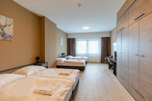 a hotel room with two beds and a desk at A22 Hotel Gyál in Gyál