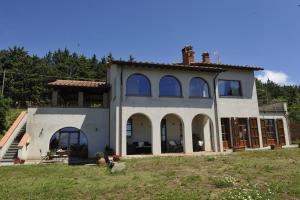 uma grande casa branca com grandes janelas em Casa vacanze La quercia del Re em Mercatale