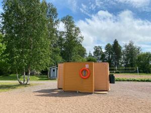 una casa exterior de madera con un anillo rojo en Myllykoski apart, en Ummeljoki