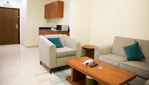 sala de estar con 2 sillas y mesa de centro en Rama Yanbu Hotel-Suite, en Yanbu