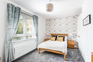 1 dormitorio con cama y ventana en Sandyhill, St. Andrews en Fife