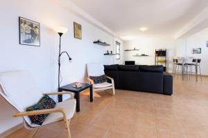 a living room with a black couch and chairs at Mirador del Roque in Órzola