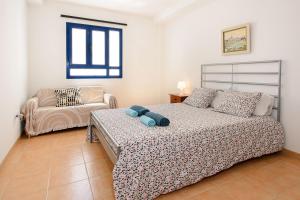 a bedroom with a bed and a couch in it at Mirador del Roque in Orzola