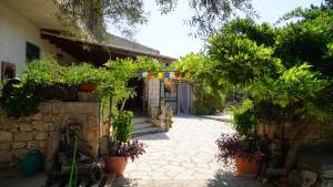 une cour avec des plantes en pot et un bâtiment dans l'établissement Casa delle Fate, à Scicli