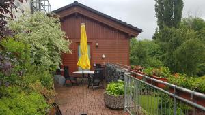 d'une terrasse avec une table et un parasol jaune. dans l'établissement pension24 Kassel, à Cassel