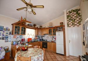 a kitchen with a table and a ceiling fan at Ikaria Studios in Manganítis