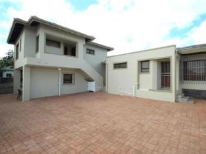 a large white house with a brick driveway at 12 on Beach Guest House in Saldanha