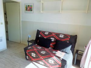 Bett mit Kissen darauf in einem Zimmer in der Unterkunft STUDIO 2 PERS QUARTIER DES PLAGES DE LA CORNICHE in Sète
