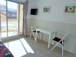 einen kleinen weißen Tisch und Stühle in einem Zimmer mit Balkon in der Unterkunft STUDIO 2 PERS QUARTIER DES PLAGES DE LA CORNICHE in Sète