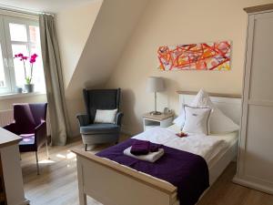 una habitación de hotel con cama, silla y avisor en Gästehaus am Markt - Leisnig en Leisnig