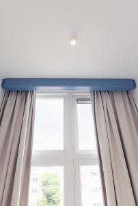 a window with curtains and a blue ledge at Hotel 171 in Rotterdam