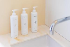 four white bottles sitting on a counter in a bathroom at Hotel 171 in Rotterdam