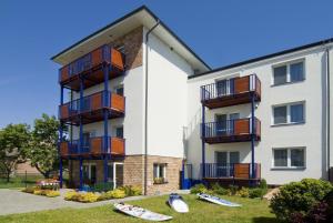 a building with surfboards on the grass in front of it at Villa Baltic Chałupy - Apartament nr 1 in Chałupy