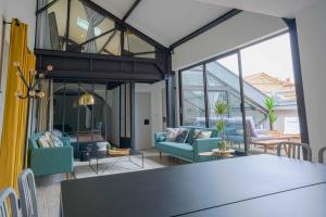 ein offenes Wohnzimmer mit einem Tisch und Stühlen in der Unterkunft NOCNOC - Le Loft, terrasse comédie in Montpellier