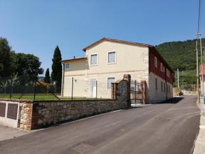 a house with a stone wall next to a street at Villavecchia in Castegnero