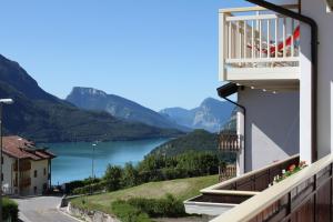 uma varanda com vista para um lago e para as montanhas em Appartamenti Residenza Pineta em Molveno