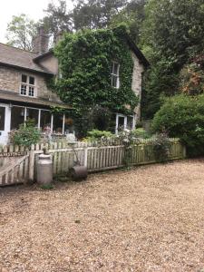 una casa con una valla de madera delante de ella en Littlebank Country House en Settle