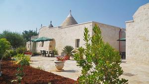 a building with a patio with a table and chairs at Trulli e Cummerse in Locorotondo