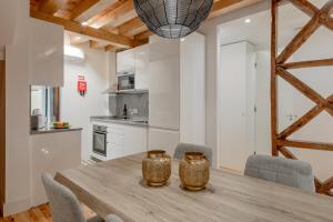 eine Küche und ein Esszimmer mit einem Holztisch und Stühlen in der Unterkunft Comtesse Lisbonne Apartments in Lissabon