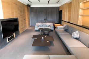 sala de estar con sofá y TV en He-Jia Hotel, en Miaoli