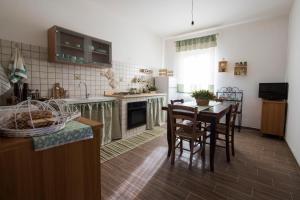 cocina con mesa y sillas y cocina con encimera en La Casetta, en Brancaleone Marina