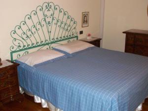 a bedroom with a bed with a blue and white blanket at Casa Daniela in Pietrasanta
