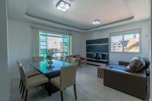 ein Wohnzimmer mit einem Tisch und einem Sofa in der Unterkunft Aluguel Apartamento 2 quartos vista mar Bombas/SC in Bombinhas