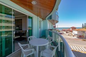 einen Balkon mit einem Tisch und Stühlen sowie Meerblick in der Unterkunft Aluguel Apartamento 2 quartos vista mar Bombas/SC in Bombinhas
