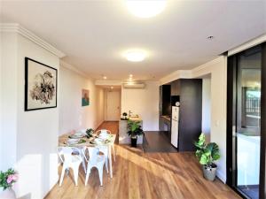 a kitchen and living room with a table and chairs at Greenview in Sydney Olympic Park in Sydney