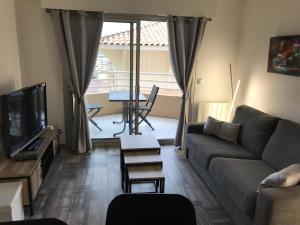 uma sala de estar com um sofá e uma televisão em APPART JL Port Fréjus em Fréjus
