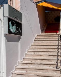 un escalier avec un panneau sur le côté du bâtiment dans l'établissement ODA Aparthotel Shkodër, à Shkodër