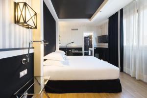 - une chambre avec un lit blanc et un bureau dans l'établissement Europark, à Barcelone