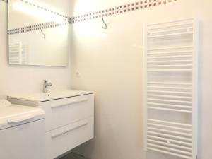 Baño blanco con lavabo y espejo en Appartement CUMARU vue mer, en Saint-Florent