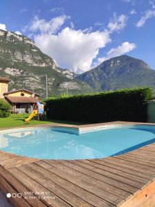 a large blue swimming pool with mountains in the background at Agriturismo Revena in Belluno Veronese
