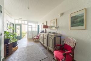 Ermitage Saint Vincent B&B في Vieille-Brioude: غرفة معيشة مع كرسي احمر وخزانة