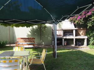 un tavolo e sedie sotto un ombrellone in un cortile di Casa Camino Santiago-Fisterra ad Amés