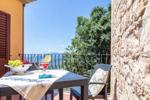 un tavolo con un bicchiere di vino sul balcone di Usuonu a Baunei