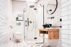 a white bathroom with a shower and a sink at Boutique Hotel De Beerze in Middelbeers
