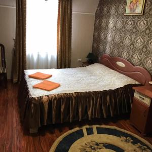 a bedroom with a bed with orange towels on it at Ідилія in Zhensna Polʼska