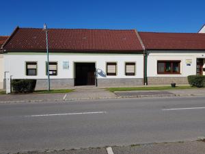 ein weißes Gebäude mit rotem Dach auf einer Straße in der Unterkunft Pension Thalhammer - Adults Only nur Erwachsene in Podersdorf am See