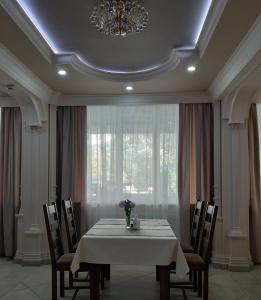 a dining room with a table and chairs and a window at Ідилія in Zhensna Polʼska
