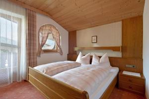um quarto com uma cama grande e uma janela em Wechselberger Johanna em Schwendau