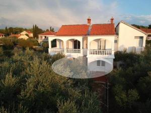 una gran casa blanca con techo rojo en Family House Rebeka en Ugljan
