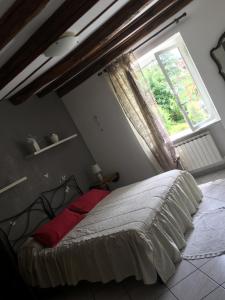 łóżko w sypialni z dużym oknem w obiekcie Il Ghiretto Appartamento w mieście Riccò del Golfo di Spezia
