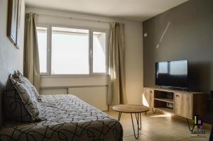 Un dormitorio con una cama y un televisor de pantalla plana. en LELOIR Suites & Meetings, en Neuquén