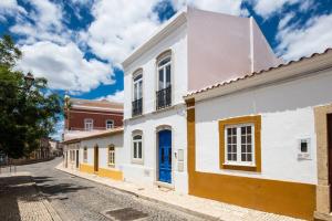 een straat in een stad met witte en gele huizen bij Casa Mourisca in Silves