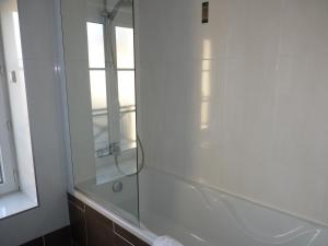 a bathroom with a shower with a glass shower door at The Originals Boutique, Hôtel de la Paix, Beaune (Qualys-Hotel) in Beaune