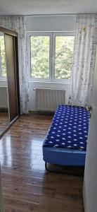 Habitación con 1 cama en una habitación con 2 ventanas en Confortable Cozy Apt en Bucarest