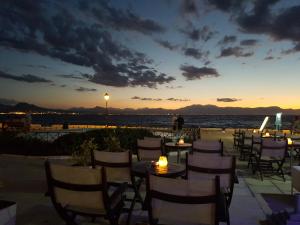 ルートラキにあるPlaza Hotelの夕日のビーチでのテーブルと椅子